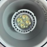 Begagnad taklampa Ogle från Atelje Lyktan. Tillverkad i svart metall med integrerad reflektor för riktbar belysning. Mått: diameter 15 cm och höjd 16,5 cm. 