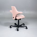 Begagnad kontorsstol med sadelsits Capisco 8106 från HÅG i rosa tyg. Mått: Justerbar sitthöjd 47 - 65.5 cm. 