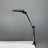 Begagnad skrivbordslampa Verit från Glamox Luxo med klämfäste i svart. Mått: höjd 85 cm.