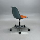 Begagnad stol med hjul Eames Plastic Side Chair PSCC från Vitra i grå plast med orange sittdyna, kromat underrede. Mått: Bredd 46,5 cm, djup 55 cm, höjd 76–88,5 cm. 