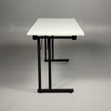 Begagnat hopfällbart bord från RBM, modell Ultima. Rektangulär bordsskiva i vitt och benen är svarta. Mått: bredd 140 cm, djup 60 cm och höjd 72 cm. 