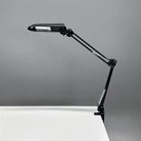 Begagnad skrivbordslampa Verit från Glamox Luxo med klämfäste i svart. Mått: höjd 85 cm.