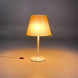 Begagnad bordslampa Melampo från Artemide i beige färg och silverstativ. Mått: Diameter 35 cm, höjd justerbar mellan 63 till 86 cm. 