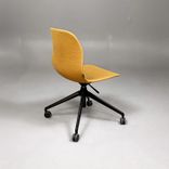 Begagnad stol med hjul Pelican från Johanson Design. Klädsel i senapsgult på svart underrede. Mått: Bredd 55 cm, Djup 50 cm, Sitthöjd justerbar från 43 till 54 cm.  