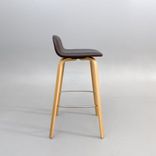 Begagnad barstol Visu från Muuto med sits i brunt skinn, ben i ek. Mått: bredd 41.3 cm, djup 40.1 cm, höjd 79 cm, sitthöjd 65 cm. 