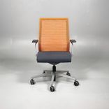 Begagnad kontorsstol från Steelcase, modell Think. Med sits i mörkgrått och rygg i orange mesh. Mått: Justerbar sitthöjd 41 till 53 cm. 
