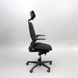 Kontorsstol från Savo med svart tygklädsel, armstöd, nackstöd, svart stolskryss med hjul. 