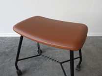 Begagnad pall på hjul Motus från Materia. Sits klädd i brunt läder, svart stativ. Mått: bredd 53 cm, djup 37 cm, höjd 48 cm. 