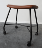 Begagnad pall på hjul Motus från Materia. Sits klädd i brunt läder, svart stativ. Mått: bredd 53 cm, djup 37 cm, höjd 48 cm. 