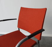 Begagnad konferensstol Spira från Lammhults. I orange färg, armstöd av svart plast och stativ i grått. Mått: bredd 55 cm, djup 56 cm, höjd 83 cm, sitthöjd 45 cm. 