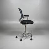 Begagnad stol med hjul från Savo, Invite High i mörkgrå/svart färg. Stolen har svängbara hjul, armstöd, justerbar sitthöjd mellan 65 till 85 centimeter och ett kromat underrede. Den erbjuder bra komfort för långa sessioner.
