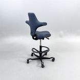 Begagnad kontorsstol med sadelsits Capisco 8106 från HÅG i blågrått tyg. Mått: Sitthöjd justerbar från 47 till 65.5 cm. 