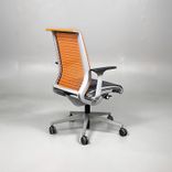 Begagnad kontorsstol från Steelcase, modell Think. Med sits i mörkgrått och rygg i orange mesh. Mått: Justerbar sitthöjd 41 till 53 cm. 