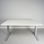 Begagnat höj och sänkbart skrivbord i vitt med silvrigt stativ. Mått: bredd 140 cm och djup 80 cm, justerbar höjd 70 - 120 cm. 