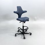 Begagnad kontorsstol med sadelsits Capisco 8106 från HÅG i blågrått tyg. Mått: Sitthöjd justerbar från 47 till 65.5 cm. 