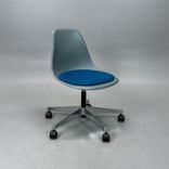 Begagnad stol med hjul Eames Plastic Side Chair PSCC från Vitra med grått plastskal, blå sittdyna, kromat underrede. Mått: Bredd 46,5 cm, djup 55 cm, höjd 76–88,5 cm. 