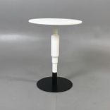 Begagnat vitt runt cafébord från Minus Tio, modell Cosmos. Pelarstativ i vitt med svart fot. Mått: Höjd 73 cm, diameter 58 cm. Passar utmärkt i moderna rum såsom fikarum eller loungen.