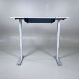 Begagnat höj- och sänkbart skrivbord Dynadesk från Work Motions. Bordsskiva i grå/vit. Mått: Bredd 140 cm, djup 80 cm, justerbar höjd från 70 till 120 cm. 
