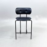Begagnad barstol Coco från GUBI i svart läder med svartlackerade ben, ryggstöd och integrerat fotstöd. Mått: Bredd 51 cm, djup 52 cm, höjd 98 cm och sitthöjd 65 cm. 