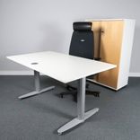 Begagnat höj- och sänkbart skrivbord Serie T från Kinnarps. Med vit laminatskiva samt silverfärgat stativ. Mått bredd 140 cm, djup 80 cm, höjd 62 - 128 cm. 