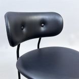 Begagnad barstol Coco från GUBI i svart läder med svartlackerade ben, ryggstöd och integrerat fotstöd. Mått: Bredd 51 cm, djup 52 cm, höjd 98 cm och sitthöjd 65 cm. 