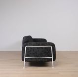 Begagnad 3-sits soffa Mega från Massproductions. Mått: längd 230 cm, höjd 78 cm. Med runda sidopaneler av vitt stål som omger och lyfter de svartmönstrade dynorna. 