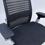 Begagnad kontorsgrupp från Steelcase med kontorsstol Think i mörkgrå/svart och höj-och sänkbart skrivbord Migration i vitt. Bredd 120 cm, Djup 60 cm. 