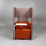 Begagnad fåtölj med hög rygg Podseat från Martela i brun/orange färg med vitt bord. Mått: Bredd 70 cm x Djup 65 cm x Höjd 126 cm. 