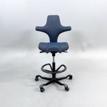 Begagnad kontorsstol med sadelsits Capisco 8106 från HÅG i blågrått tyg. Mått: Sitthöjd justerbar från 47 till 65.5 cm. 