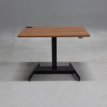 Begagnat höj och sänkbart skrivbord med bordsskiva i laminat finish av valnöt, stativ i  svart. Mått: bredd 100 cm, djup 70 cm, justerbar höjd mellan 64 till 115 cm. 