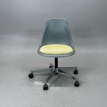 Begagnad Vitra Eames Plastic Side Chair PSCC med grått plastskal, ljusgul sittdyna, kromat underrede och hjul. Mått: Bredd 46,5 cm, djup 55 cm, höjd 76–88,5 cm. 