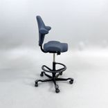 Begagnad kontorsstol med sadelsits Capisco 8106 från HÅG i blågrått tyg. Mått: Sitthöjd justerbar från 47 till 65.5 cm. 
