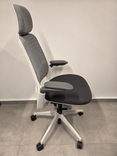Begagnad kontorsstol Serie 1 från Steelcase med meshrygg och nackstöd. I två olika grå nyanser. Mått: Höjd 112-124 cm x Bredd 66 cm x Djup 70 cm.  