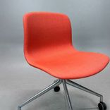 Begagnad stol med hjul AAC15 från HAY. Med tegelröd tygklädsel och kromat kryssunderrede. Mått: Bredd 51 cm, djup 52 cm, höjd 77 cm och sitthöjd 46 cm. 