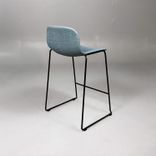 Begagnad barstol Neo från Materia med blågrön klädsel, svart underrede och integrerat fotstöd. Mått: bredd 55 cm, djup 46 cm, höjd 83 cm, sitthöjd 63 cm. 
