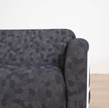 Begagnad 3-sits soffa Mega från Massproductions. Mått: längd 230 cm, höjd 78 cm. Med runda sidopaneler av vitt stål som omger och lyfter de svartmönstrade dynorna. 