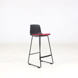 Begagnad barstol Lottus från Enea i svart med röd sits. Mått: Sitthöjd 66 cm och total höjd 88 cm. 