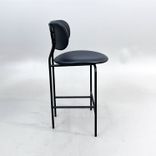 Begagnad barstol Coco från GUBI i svart läder med svartlackerade ben, ryggstöd och integrerat fotstöd. Mått: Bredd 51 cm, djup 52 cm, höjd 98 cm och sitthöjd 65 cm. 