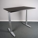 Begagnat höj- och sänkbart skrivbord Serie T från Kinnarps. I svart med silvriga ben. Mått: Bredd 120 cm, Djup 80 cm, Höjd justerbar från 61.5 till 128 cm. 