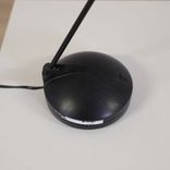 Begagnad skrivbordslampa Joker från Unilux i svart. Mått: Höjd 60 cm, fotens bredd 15 cm.