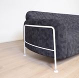 Begagnad 3-sits soffa Mega från Massproductions. Mått: längd 230 cm, höjd 78 cm. Med runda sidopaneler av vitt stål som omger och lyfter de svartmönstrade dynorna. 