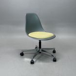 Begagnad Vitra Eames Plastic Side Chair PSCC med grått plastskal, ljusgul sittdyna, kromat underrede och hjul. Mått: Bredd 46,5 cm, djup 55 cm, höjd 76–88,5 cm. 