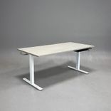 Begagnat höj och sänkbart skrivbord i med ljusgrått bordsskiva och vitt stativ. Mått: Bredd 160 cm, Djup 80 cm, Höjd justerbar från 70 till 120 cm. 