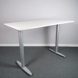 Begagnat höj- och sänkbart skrivbord Serie T från Kinnarps. Bordsskiva i vitt med stativ i silver. Mått: bredd 160 cm, djup 80 cm, Höjd 61.5 cm till 128 cm. 