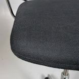 Begagnad stol med hjul från Savo, Invite High i mörkgrå/svart färg. Stolen har svängbara hjul, armstöd, justerbar sitthöjd mellan 65 till 85 centimeter och ett kromat underrede. Den erbjuder bra komfort för långa sessioner.