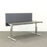 Begagnad bordsskärm, rektangulär i mörkgrått. Mått: längd 80 cm, höjd 60 centimeter. Denna produkt erbjuder visuell avskildhet samt ljudabsorption, perfekt anpassad för kontorsmiljö.