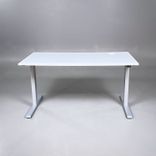 Begagnat höj- och sänkbart skrivbord. Bordsskiva är ljusgrå med stativ i silver. Mått: Bredd 140 cm, Djup 70 cm, justerbar höjd mellan 70 till 120 cm. 