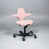 Begagnad kontorsstol med sadelsits Capisco 8106 från HÅG i rosa tyg. Mått: Justerbar sitthöjd 47 - 65.5 cm. 