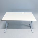 Begagnat höj- och sänkbart skrivbord med vit bordsskiva svart kant och silverfärgade ben. Mått: bredd 110 cm och djup 90 cm, Justerbar höjd 70 - 120 cm. 