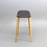 Begagnad barstol Visu från Muuto med sits i brunt skinn, ben i ek. Mått: bredd 41.3 cm, djup 40.1 cm, höjd 79 cm, sitthöjd 65 cm. 